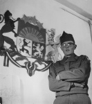Karavīrs pie Latvijas valsts ģērboņa.