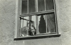 Terēze Skariņš skatās no savas istabas loga 