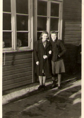 Divas draudzenes Nellija Ladusāns un Ērika Šteins pie vidusskolas barakas